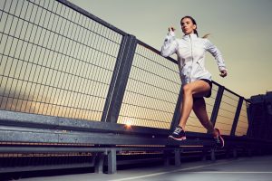 Athletic,Woman,Running,During,Sunset,On,Rooftop,Of,Parking,,Garage